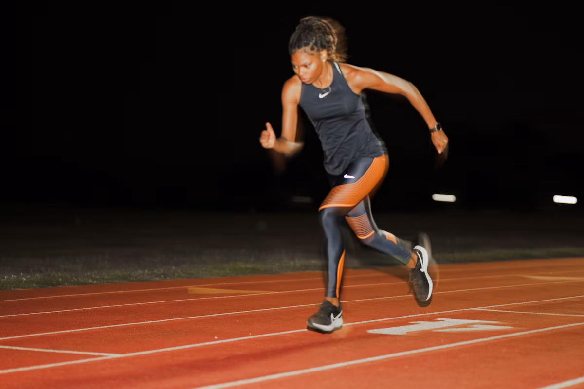 A female athlete running on the track at night